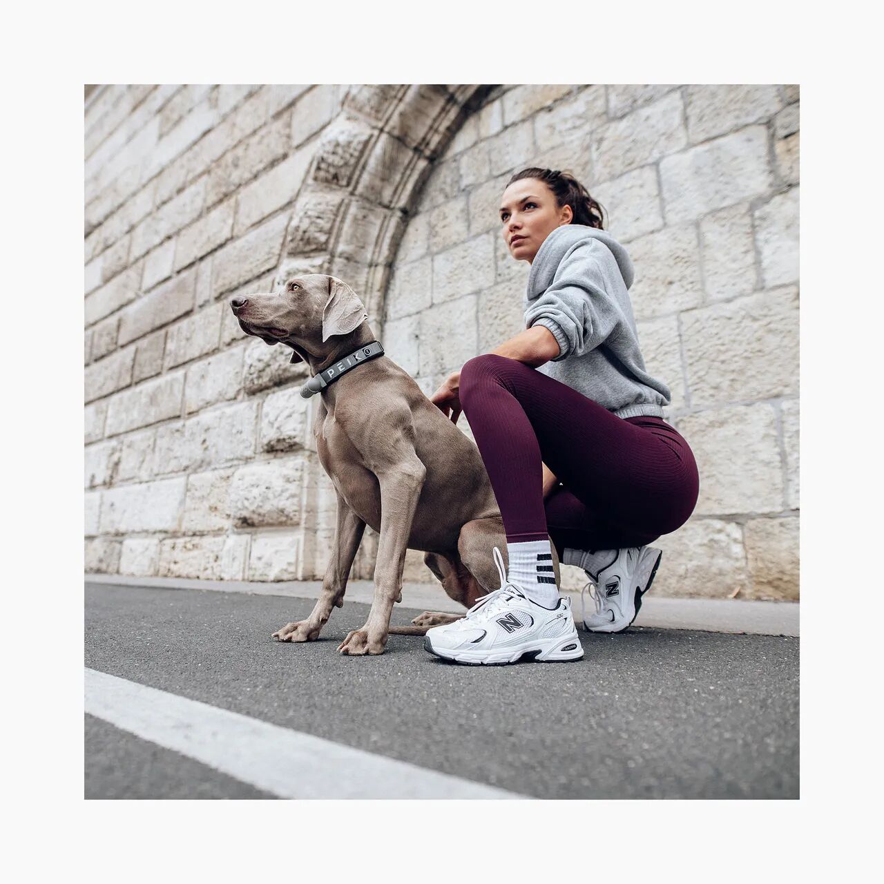 Girl with a vizsla wearing a gray PEIKO® QuickLeash™ collar in the city